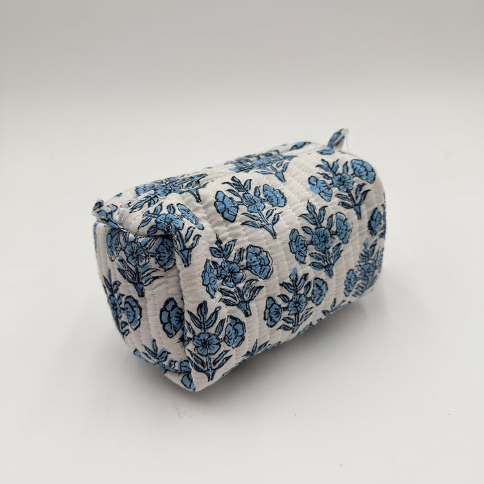 Fabric-covered cylindrical pillow with blue floral pattern on a white background