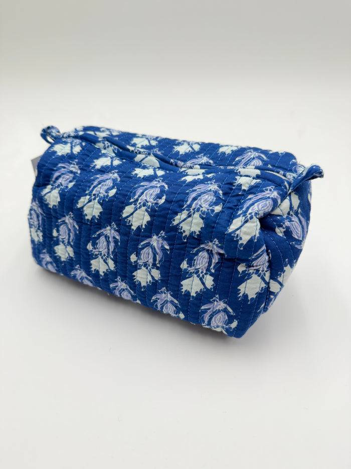 Blue fabric pouch with white floral pattern on a white background