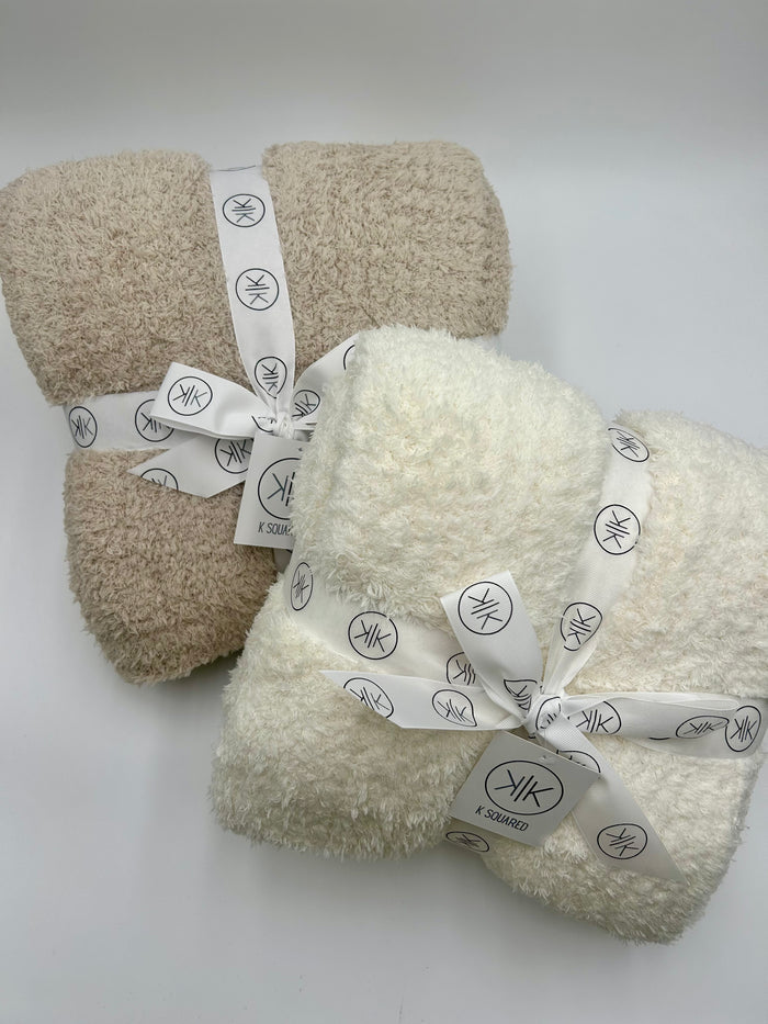 stone and cream throw blanket on white backdrop
