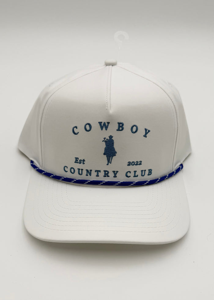 A white structured baseball cap with blue embroidered text reading 'COWBOY COUNTRY CLUB' and a small cowboy silhouette, plus a blue-and-white braided rope detail across the front, shown on a plain light background.
