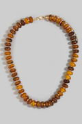 Necklace with brown and amber beads on a light gray background