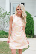 Woman wearing a pastel tie-dye dress outdoors.
