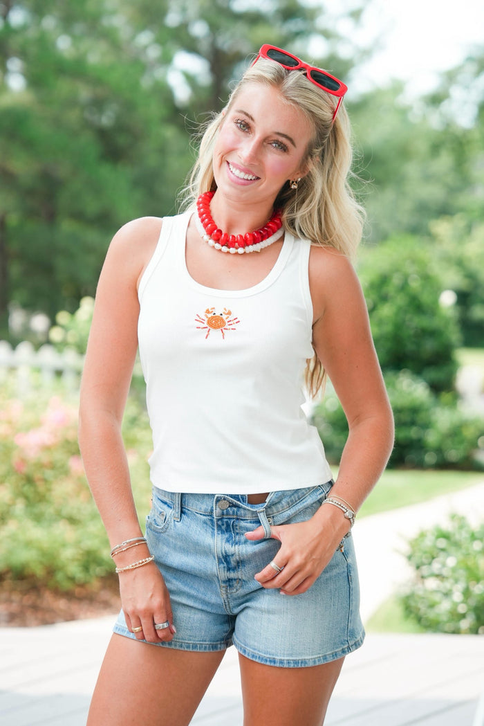 girl wearing white tank with beaded crab