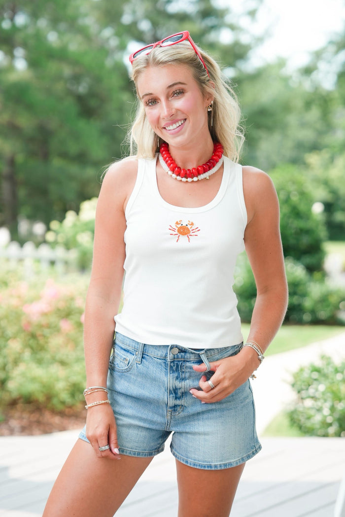 girl wearing white tank with beaded crab