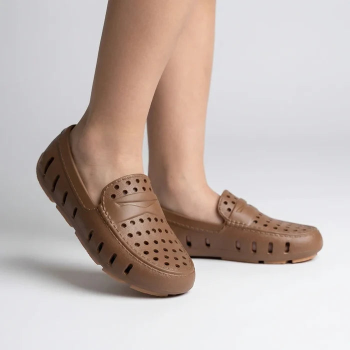 Brown leather shoes with holes on a light gray background