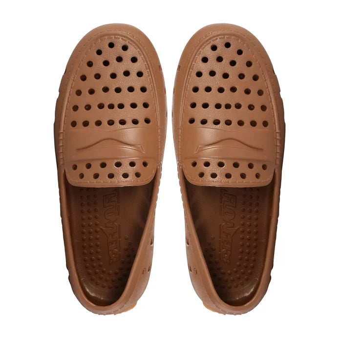 Pair of brown slip-on shoes with perforated design on a white background
