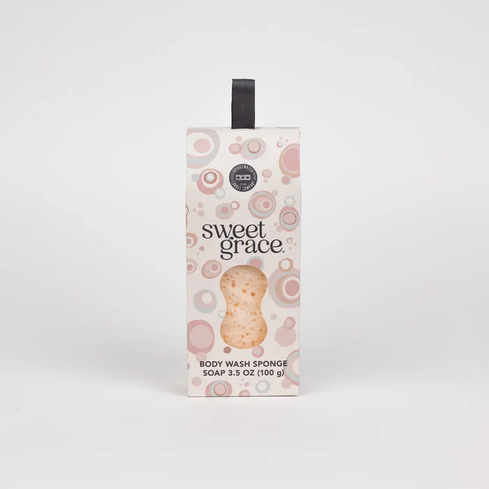 Sweet Grace body wash sponge in its original packaging, featuring a white box with pink circular patterns and a clear window showing the sponge inside.