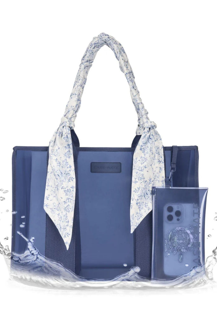 Blue tote bag with floral handle and phone case on a white background