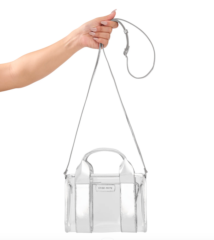 Clear handbag with a visible brand logo held by a hand on a white background