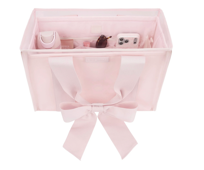 Pink storage basket with a bow on a white background