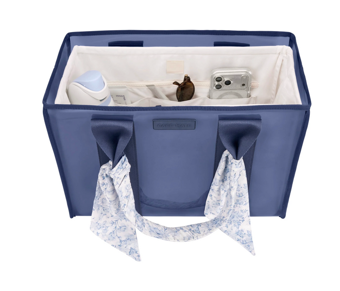 Blue organizer bag with white interior, containing items like a phone and a bottle, on a white background.