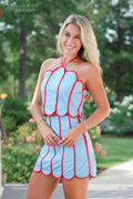 Woman wearing a blue and red dress with a floral background
