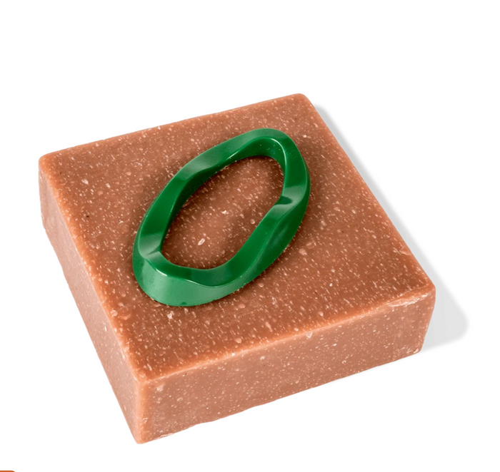 Brown square soap with a green handle on a white background
