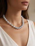 Pearl necklace worn by a model against a neutral background