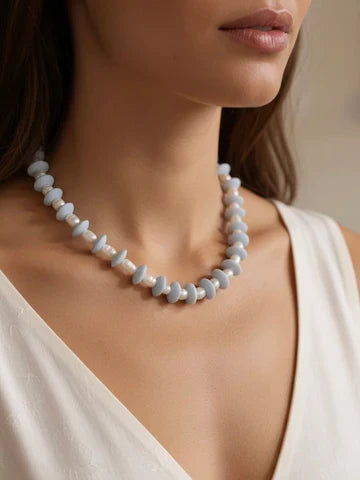 Pearl necklace worn by a model against a neutral background