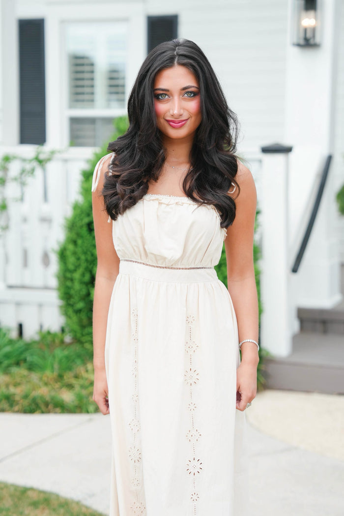 Woman in a white dress standing outdoors with a blurred background