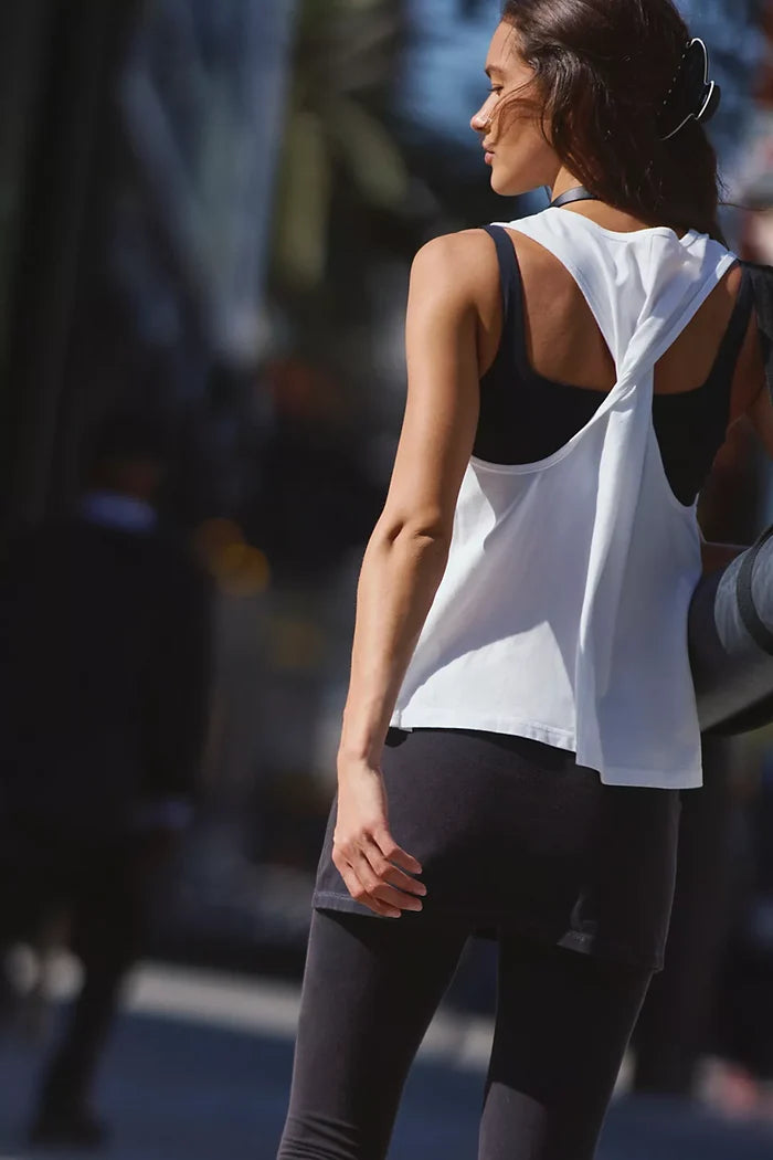 Woman in athletic wear standing outdoors with a blurred background