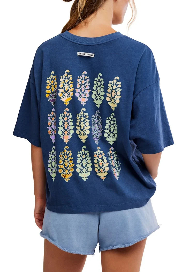 Navy blue t-shirt with colorful leaf pattern on the back, worn by a person.
