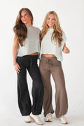 Two women modeling neutral colored shirts and pants