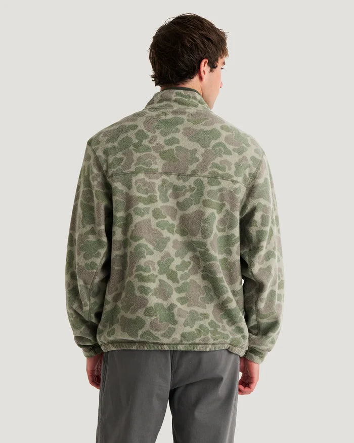 Person wearing a camouflage jacket on a plain background