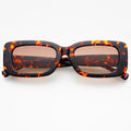 Sunglasses with tortoiseshell frame and brown lenses on a white background