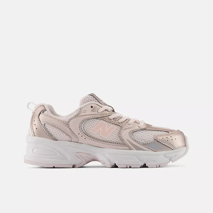 A New Balance low-top sneaker in a metallic rose gold and white colorway, shown from a side profile view against a light gray background.