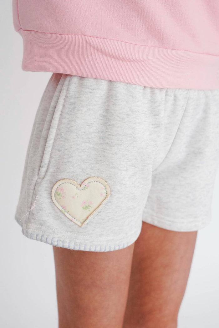 Gray shorts with a heart design on a white background