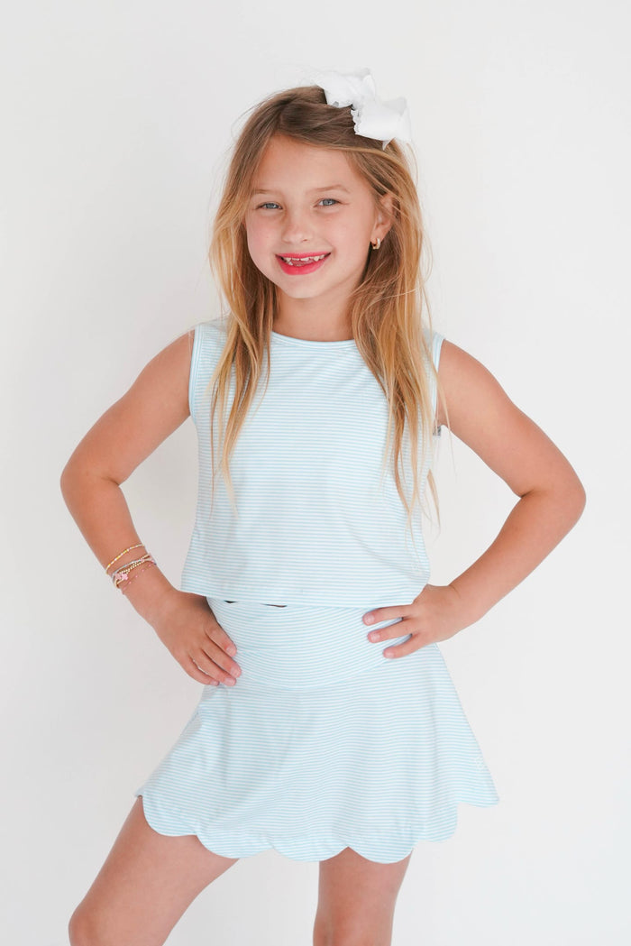 Young girl wearing a light blue dress with a white background