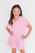 Young girl wearing a pink outfit on a white background