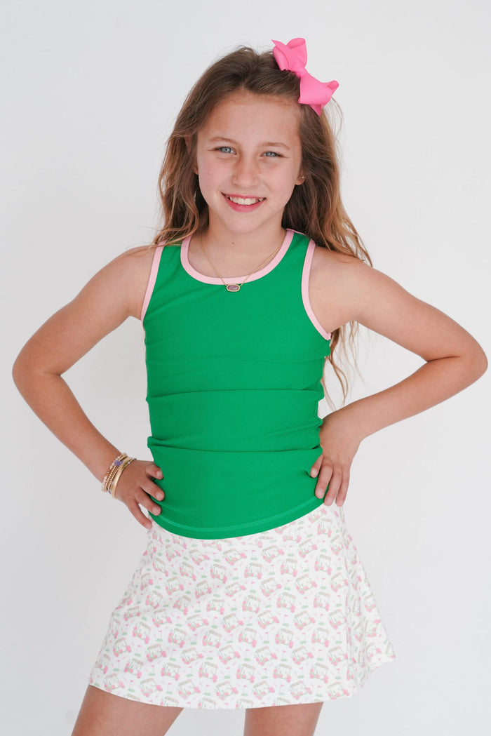 Young girl wearing a green tank top and white skirt with a floral pattern on a white background