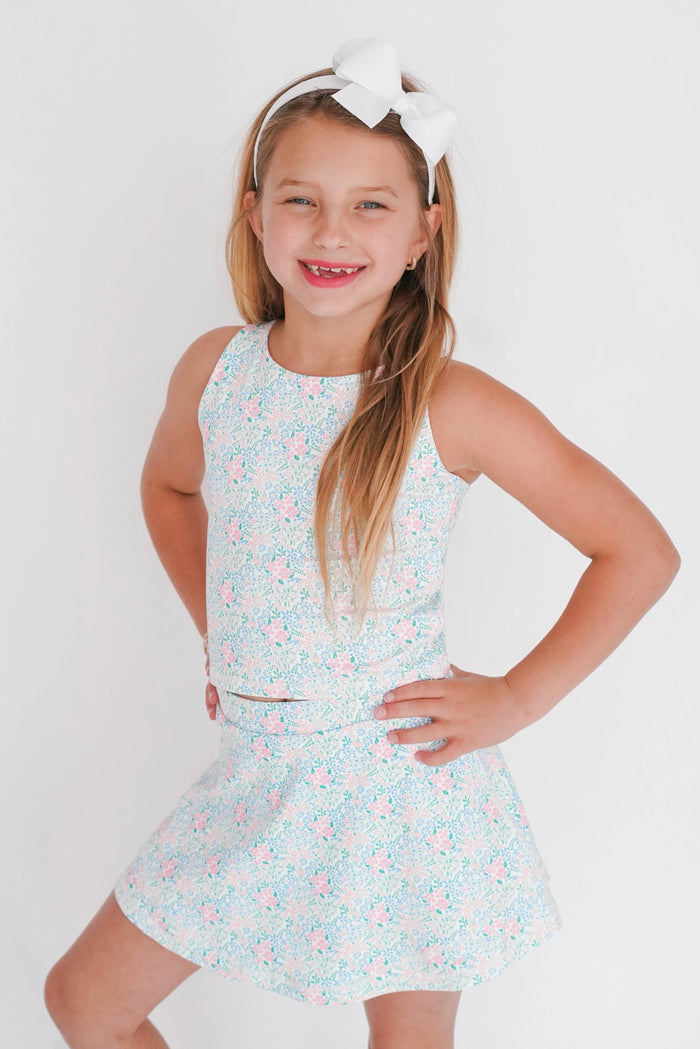 Young girl wearing a floral dress with a white background