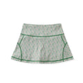 A high-waisted athletic skirt with a dense green, pink, and white floral pattern, featuring solid green contrast piping along the seams, displayed on a clean white background.