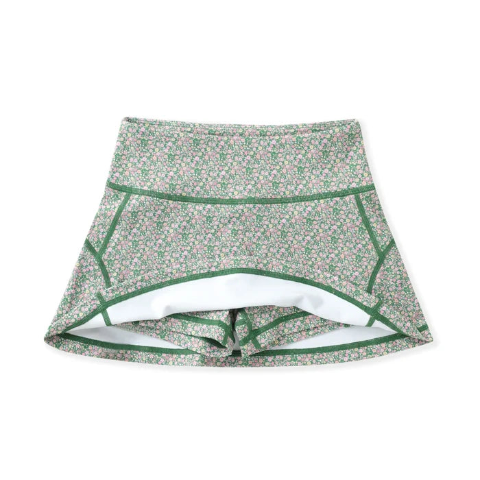 A pair of high-waisted athletic shorts featuring a dense green, pink, and white floral pattern, with solid green contrast stitching and a white interior lining.