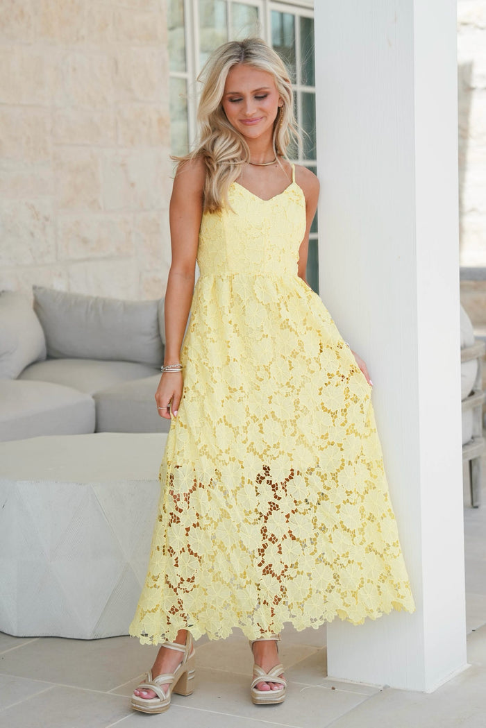 Woman wearing a yellow lace dress in an indoor setting