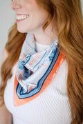 Woman wearing a colorful scarf with a design on a plain background