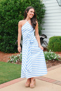 Woman wearing a blue and white striped dress standing outdoors.