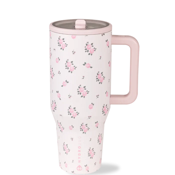 Floral-patterned travel mug with a pink handle on a white background