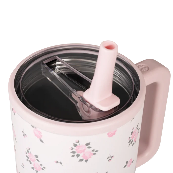 Pink floral-patterned mug with a straw lid on a white background