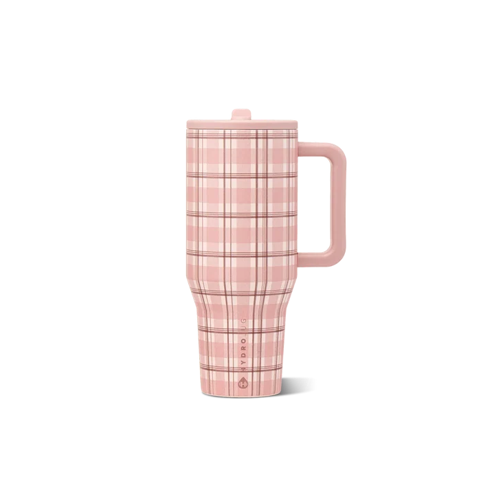 A travel tumbler with a pink and maroon plaid  pattern, featuring a dark pink handle and lid, shown on a solid white background.