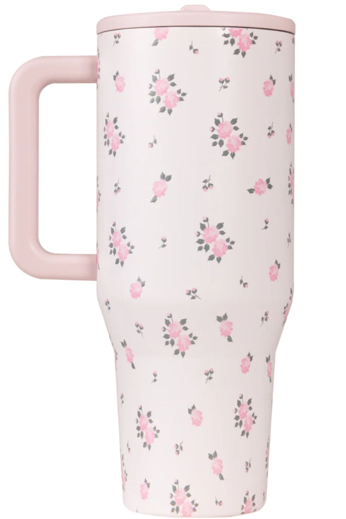 Pink floral-patterned travel mug with a handle on a white background