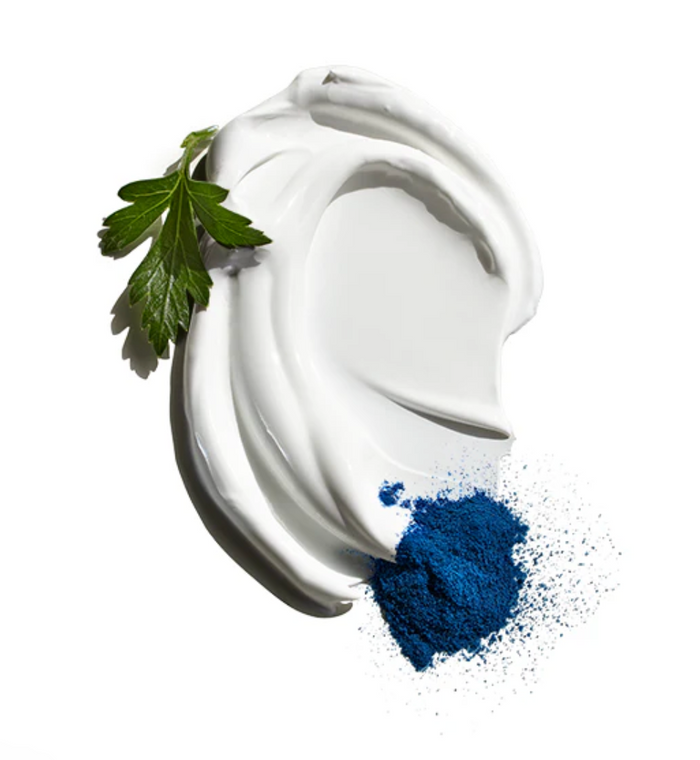 White cream swirl with a blue powder and green leaf on a white background