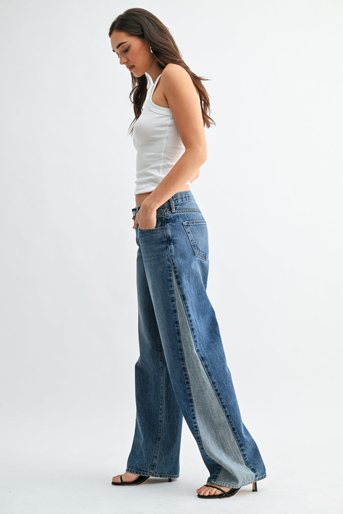 Woman wearing a white top and blue jeans on a white background