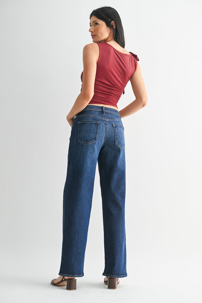Woman wearing blue jeans and a red top on a white background