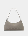 A taupe-brown studded shoulder bag by Katie Linton, featuring a crescent-shaped silhouette, a single shoulder strap, and silver-tone studs across the surface, set against a plain light gray background.