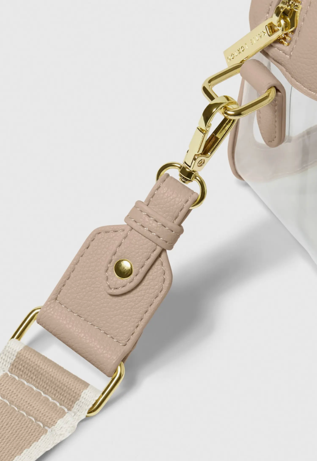 Close-up of a beige bag strap with gold hardware on a light gray background