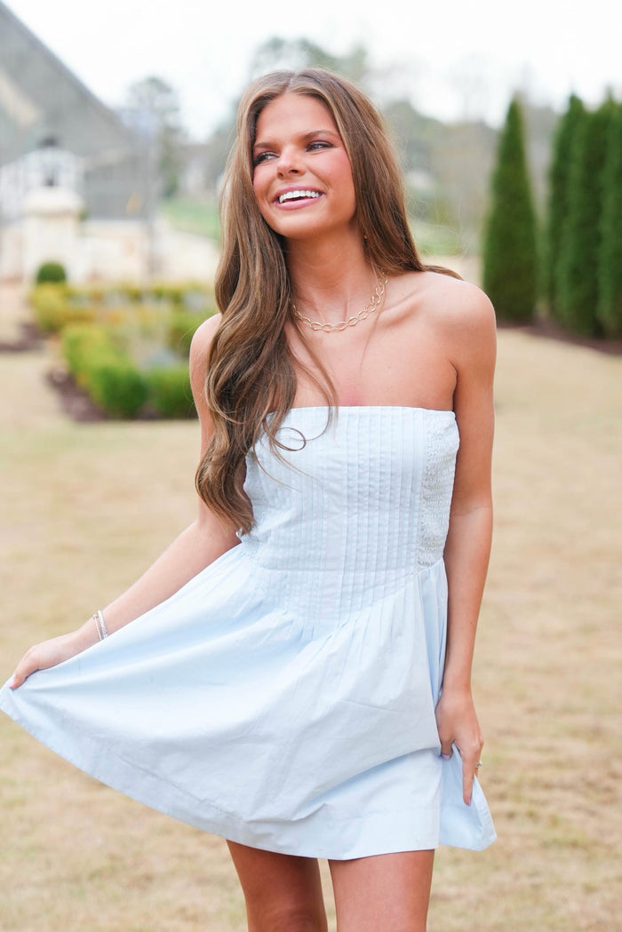 Woman wearing a light blue strapless dress outdoors