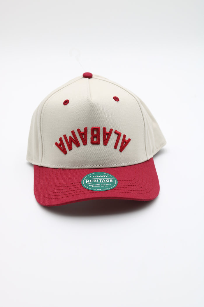 An Alabama Crimson snapback cap featuring an off-white crown with red embroidered 'ALABAMA' text and a red visor, shown on a clean white background.