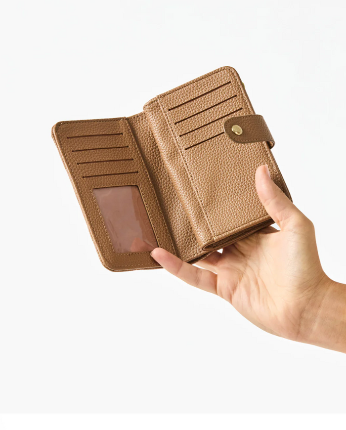 Hand holding a brown leather wallet against a white background