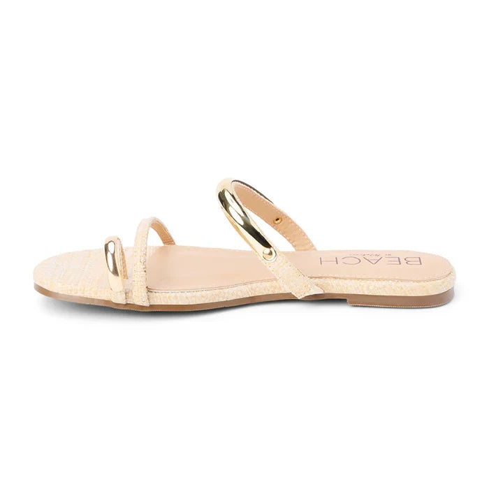 Beige sandal with gold ring on a white background
