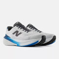 A pair of New Balance running shoes in white, black, and blue, shown from a three-quarters angle against a light gray background.